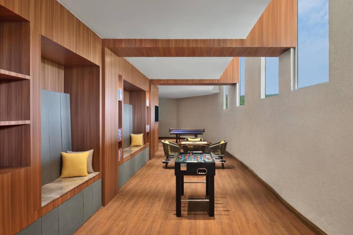 a corridor with chairs and tables in a room at Courtyard by Marriott Mahabaleshwar in Mahabaleshwar