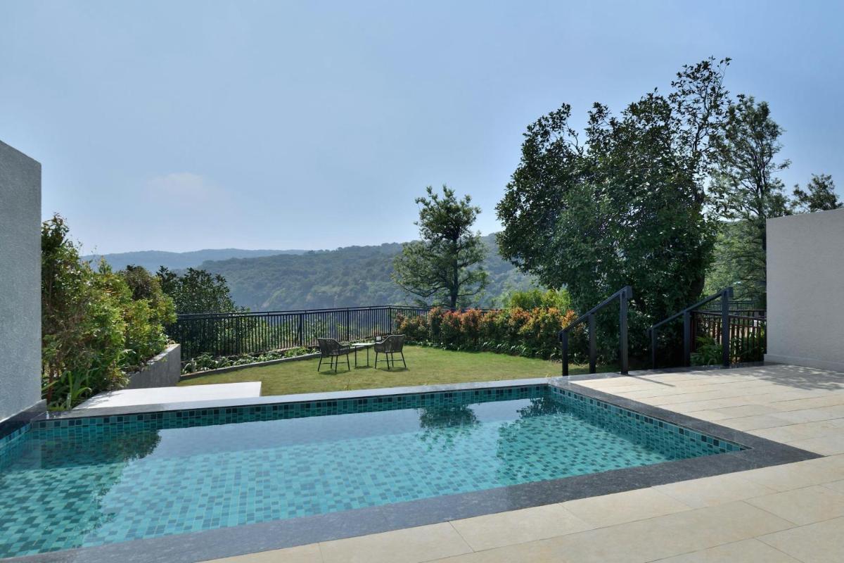a swimming pool in the middle of a yard at Courtyard by Marriott Mahabaleshwar in Mahabaleshwar