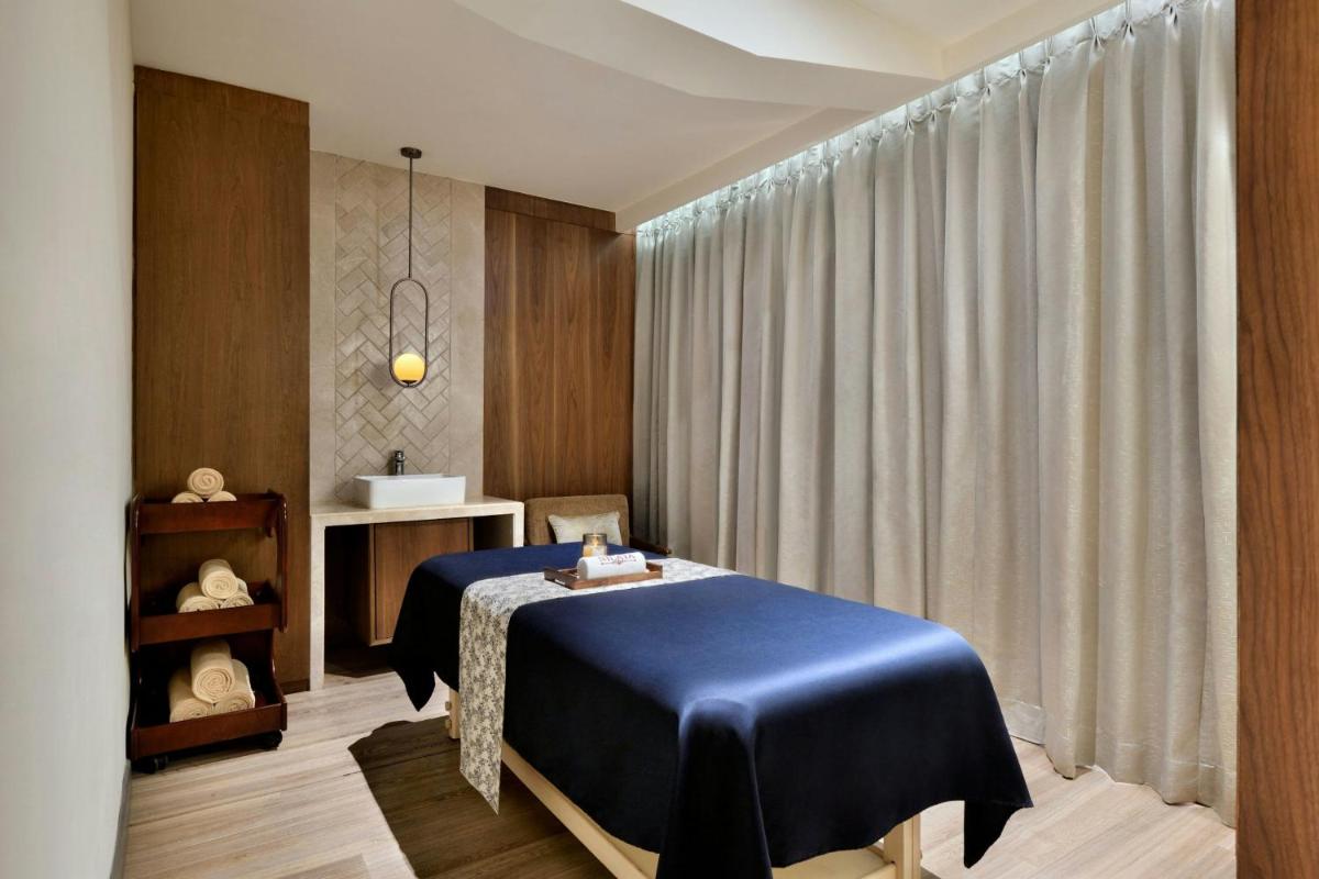 a bedroom with a blue bed in a room at Courtyard by Marriott Mahabaleshwar in Mahabaleshwar