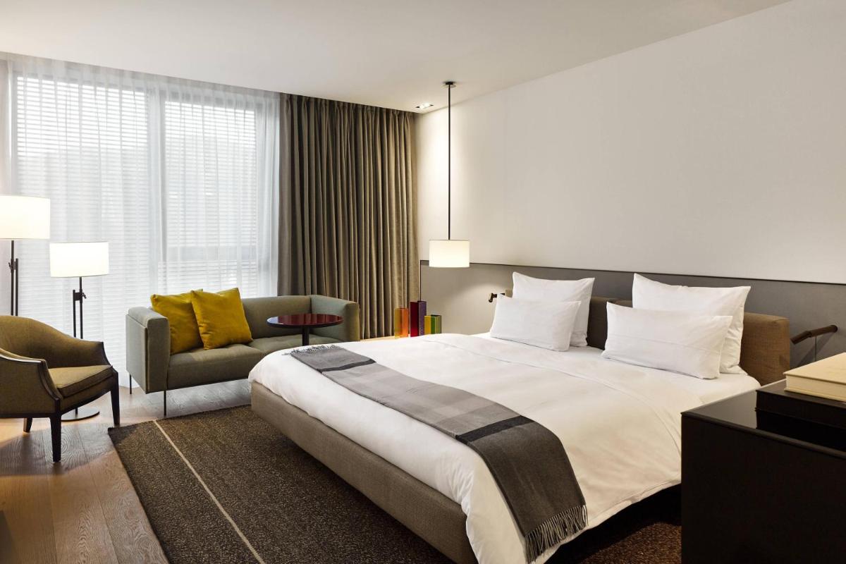 ein Schlafzimmer mit großem Bett und Couch in der Unterkunft Roomers Baden-Baden, Autograph Collection in Baden-Baden