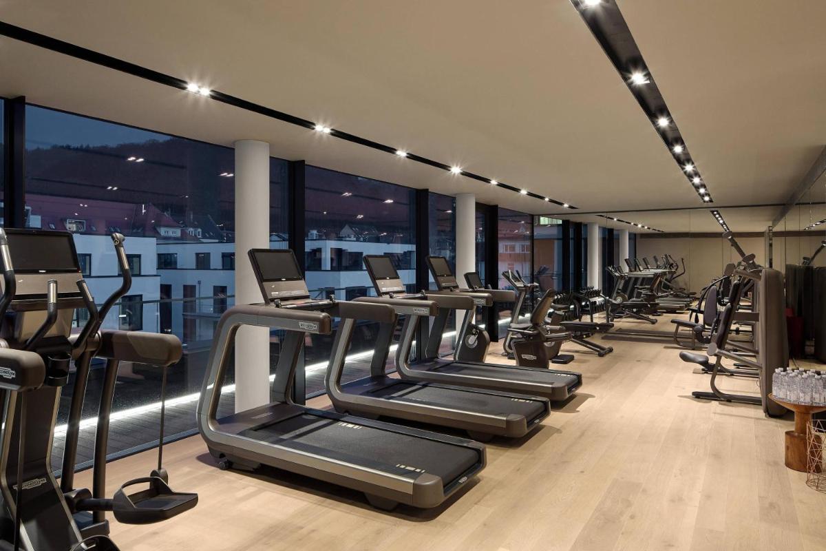 ein Fitnessstudio mit einer Reihe von Laufbändern und Crosstrainern in der Unterkunft Roomers Baden-Baden, Autograph Collection in Baden-Baden