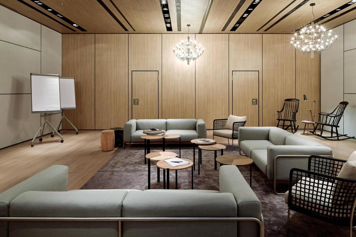 ein Wartezimmer mit Sofas, Tischen und einem Bildschirm in der Unterkunft Roomers Baden-Baden, Autograph Collection in Baden-Baden + 37 Fotos