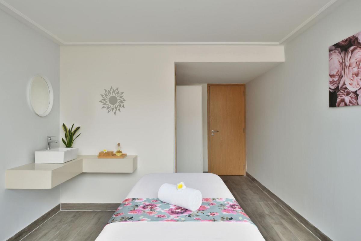 a white bedroom with a bed with a heart shaped pillow at Le Meridien Hyderabad in Hyderabad +38 photos