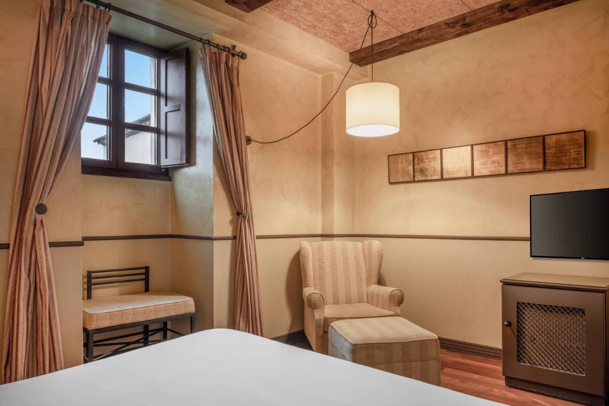 Una televisión o centro de entretenimiento en Hotel Palacio del Carmen, Autograph Collection