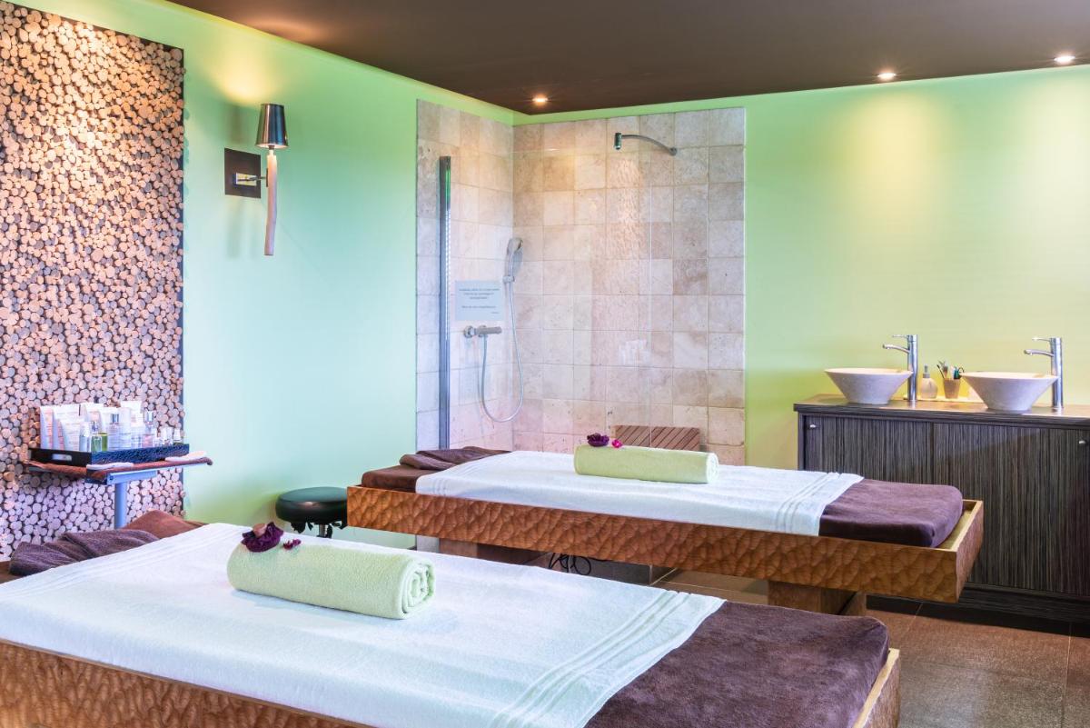 deux lits dans une chambre avec douche dans l'établissement Domaine De Villers & Spa, à Villers-sur-Mer
