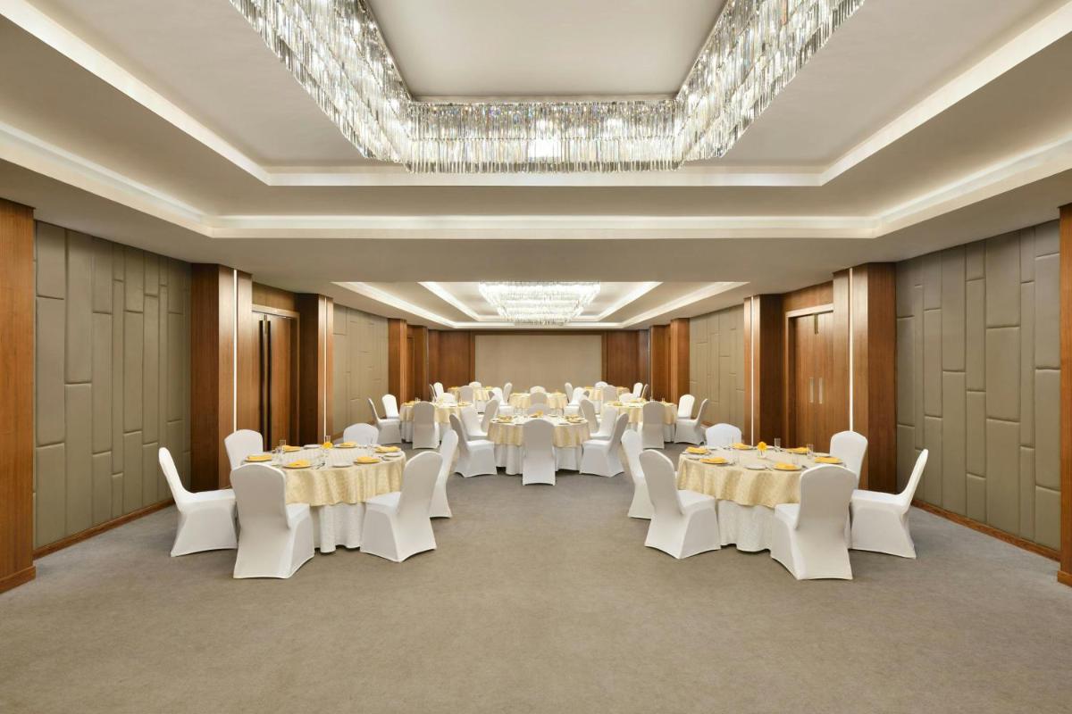 a banquet hall with white tables and white chairs at Courtyard by Marriott Mahabaleshwar in Mahabaleshwar