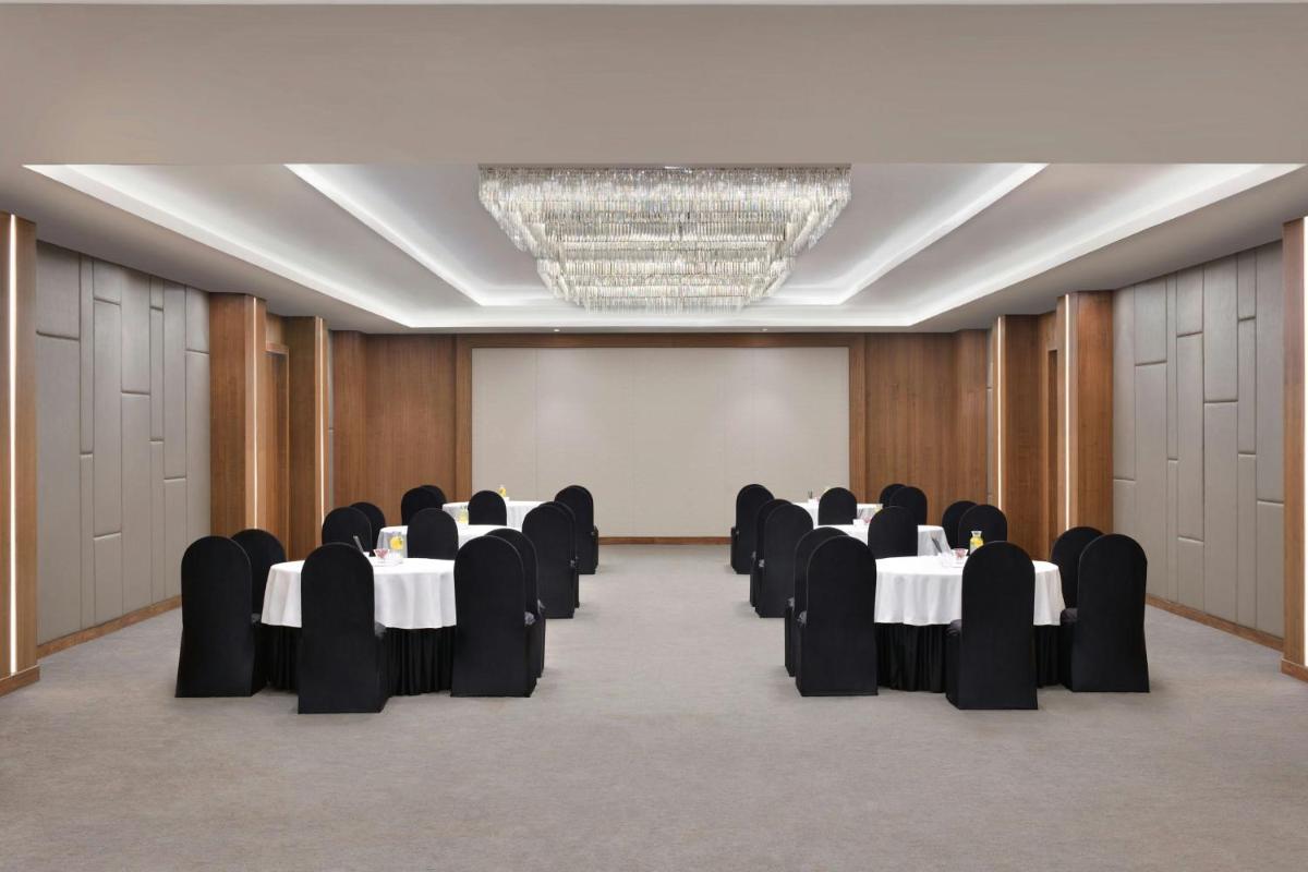 a conference room with tables and chairs and a chandelier at Courtyard by Marriott Mahabaleshwar in Mahabaleshwar