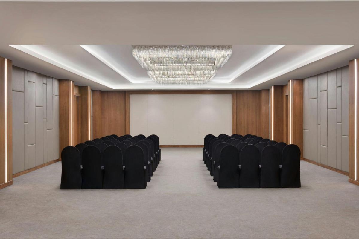 a conference room with black chairs and a chandelier at Courtyard by Marriott Mahabaleshwar in Mahabaleshwar