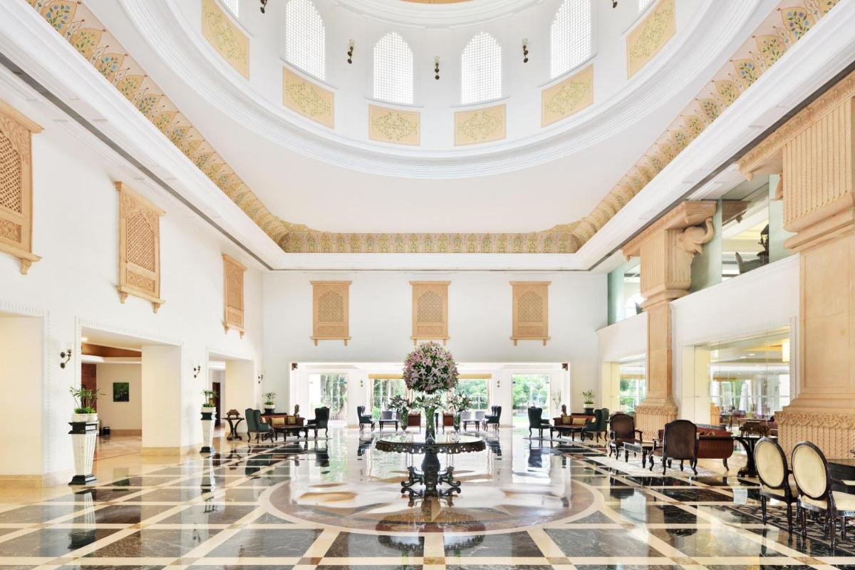 an ornate lobby with a round table and chairs at Le Meridien Jaipur Resort & Spa in Jaipur