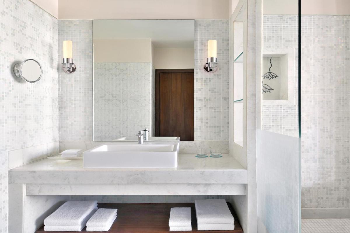 a bathroom with a sink and a mirror at Le Meridien Jaipur Resort & Spa in Jaipur