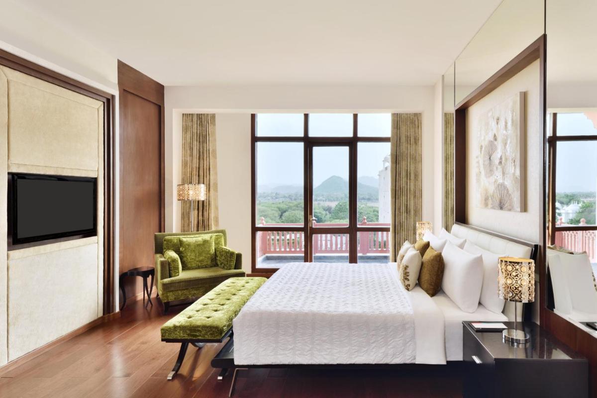 a bedroom with a bed and a large window at Le Meridien Jaipur Resort & Spa in Jaipur