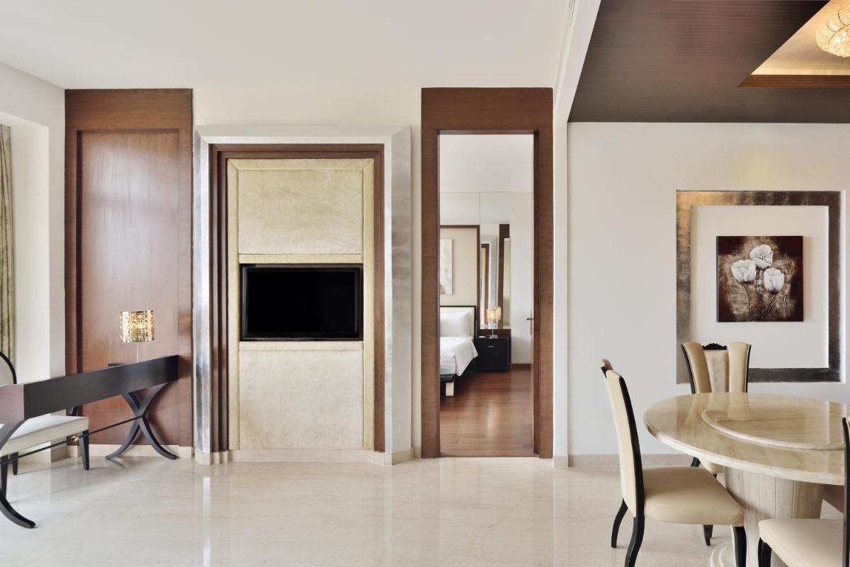 a living room with a television and a dining room at Le Meridien Jaipur Resort & Spa in Jaipur