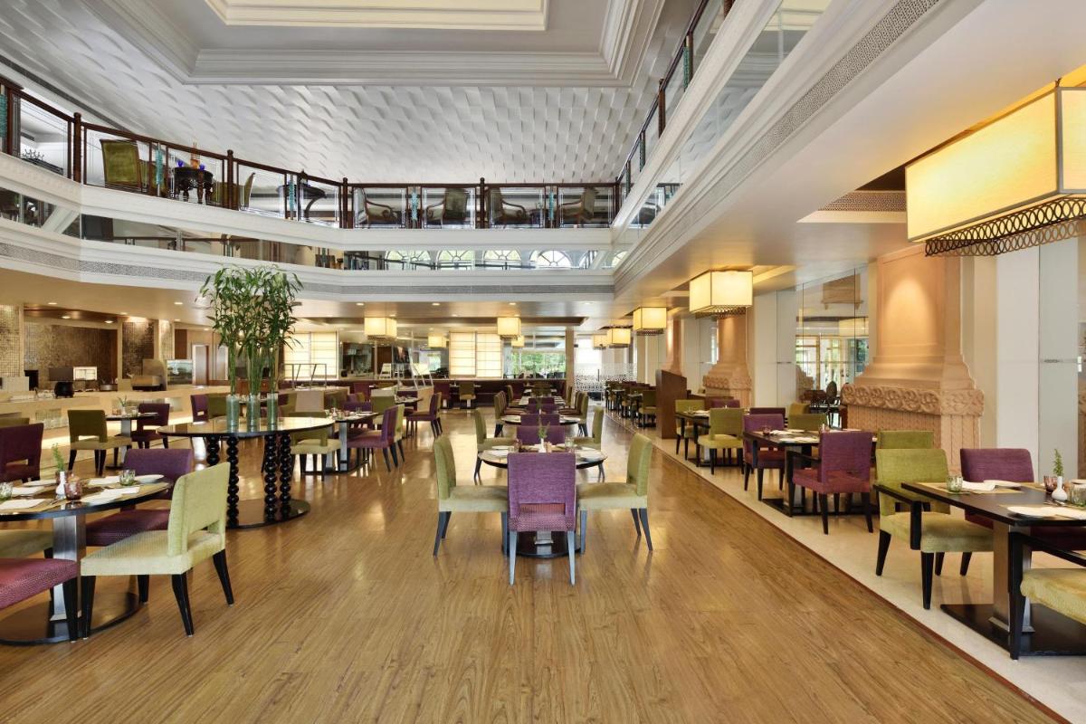 a dining room with tables and chairs and a restaurant at Le Meridien Jaipur Resort & Spa in Jaipur