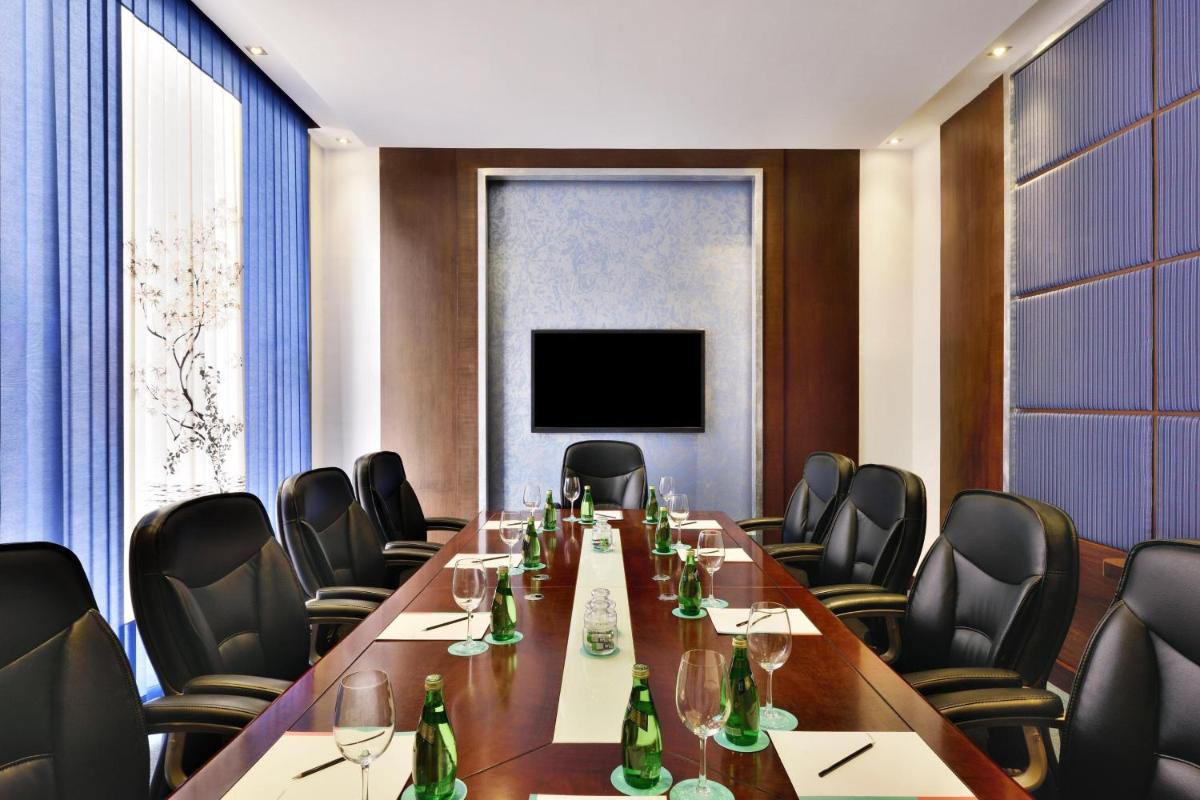 a conference room with a long table and chairs at Le Meridien Jaipur Resort & Spa in Jaipur
