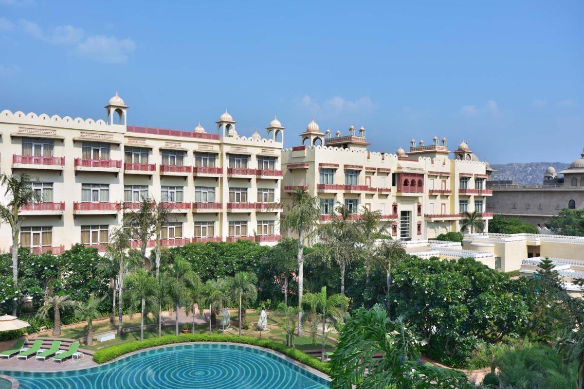 a large hotel with a pool in front of it at Le Meridien Jaipur Resort & Spa in Jaipur