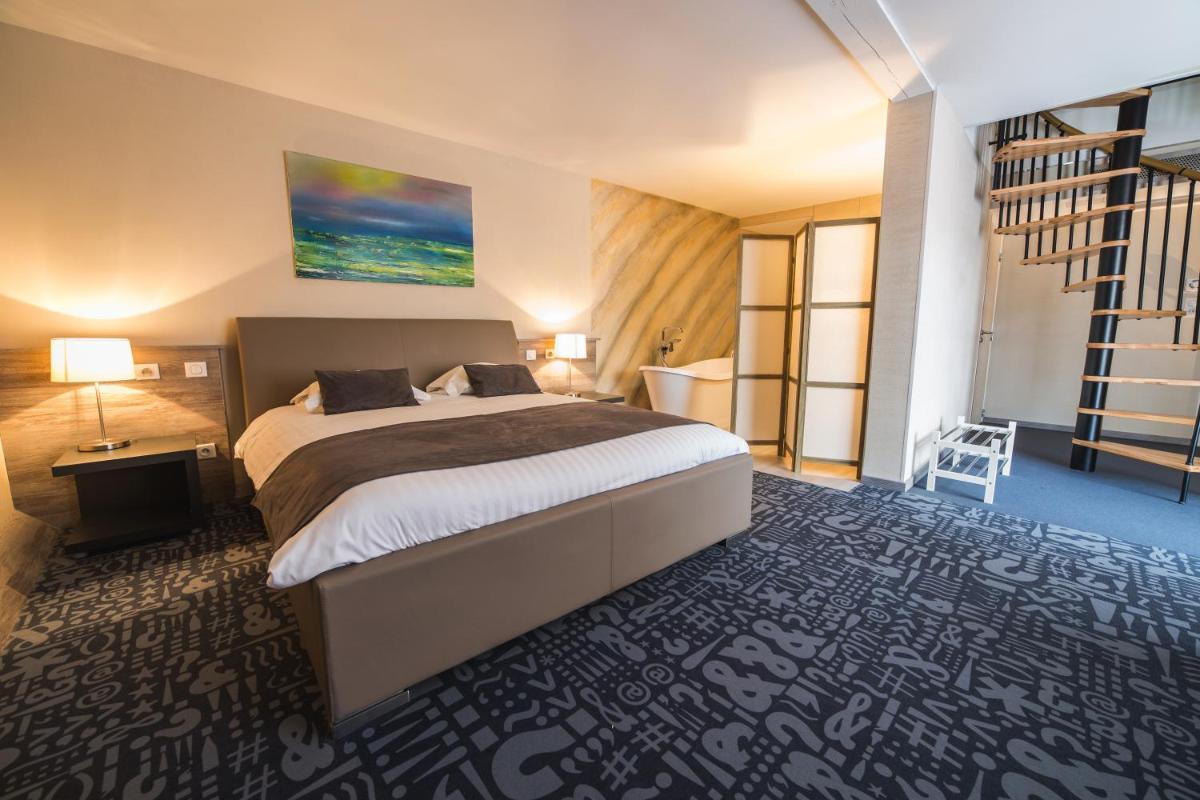 Un ou plusieurs lits dans un hébergement de l'établissement Hôtel Le Dormeur