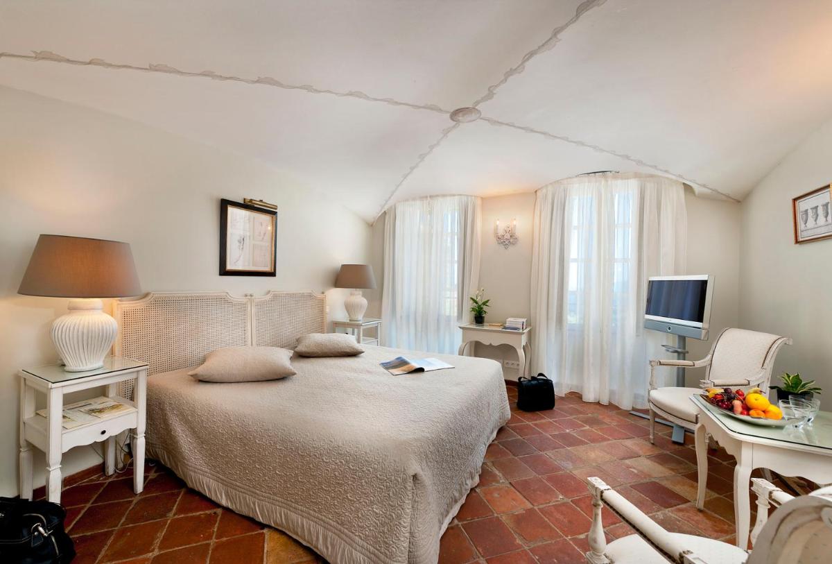 une chambre avec un lit, une table et une télévision dans l'établissement Bastide Saint Antoine - Relais & Châteaux, à Grasse