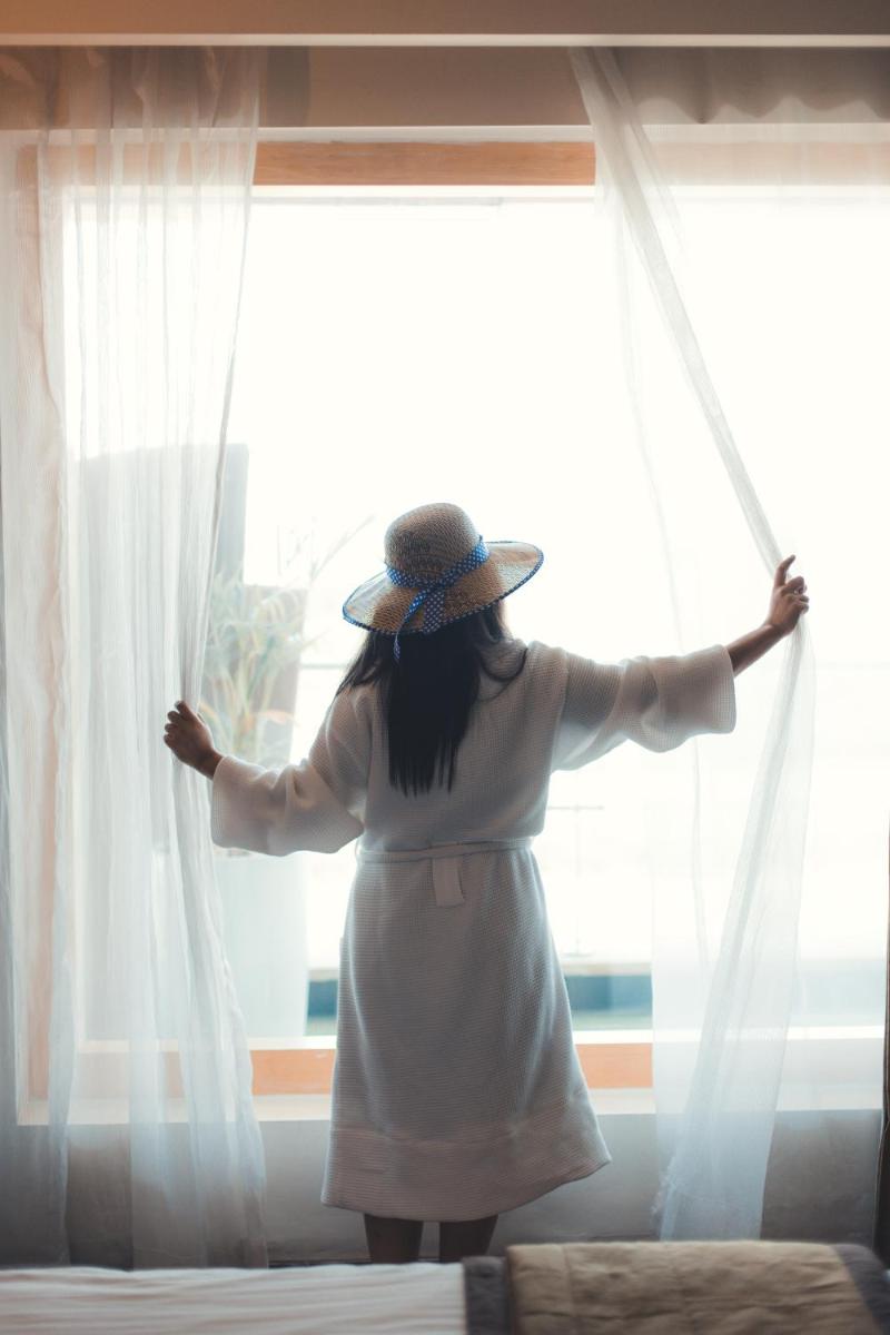 a woman in a hat standing in front of a window at Novotel Hyderabad Airport in Hyderabad