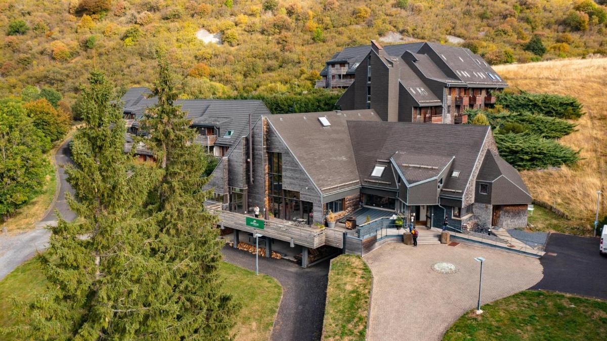 une vue aérienne d'une grande maison avec une grande maison dans l'établissement Sancy Resort, à Chambon-sur-Lac