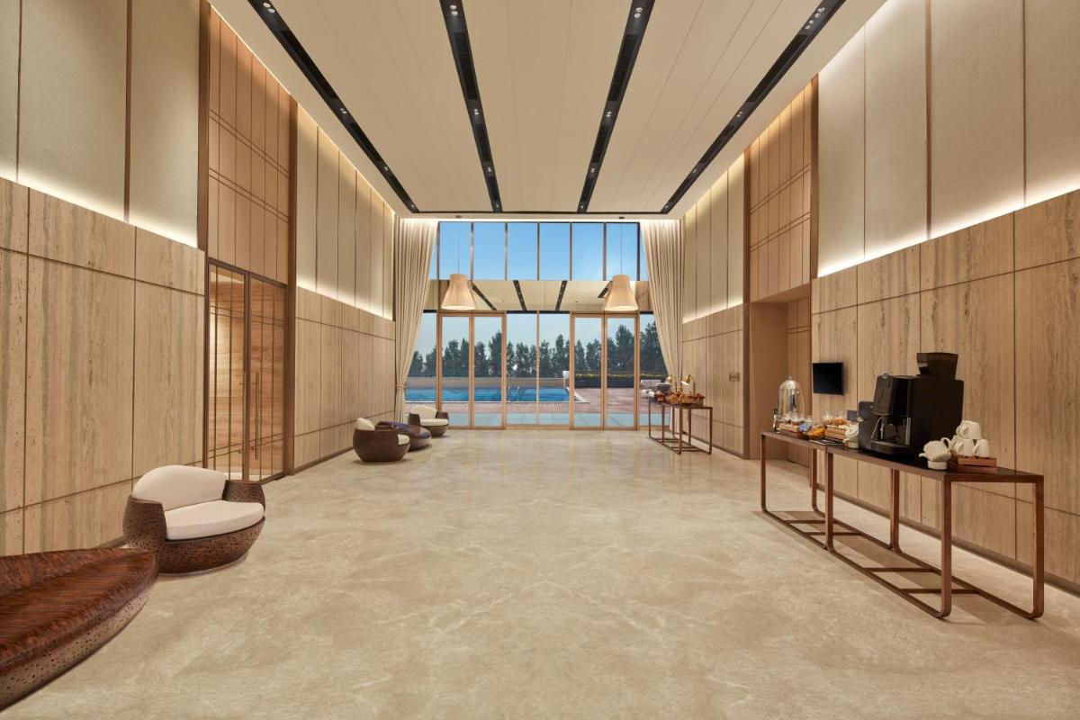 a lobby with a large window and a large room at Hilton Gurugram Baani City Centre in Gurgaon