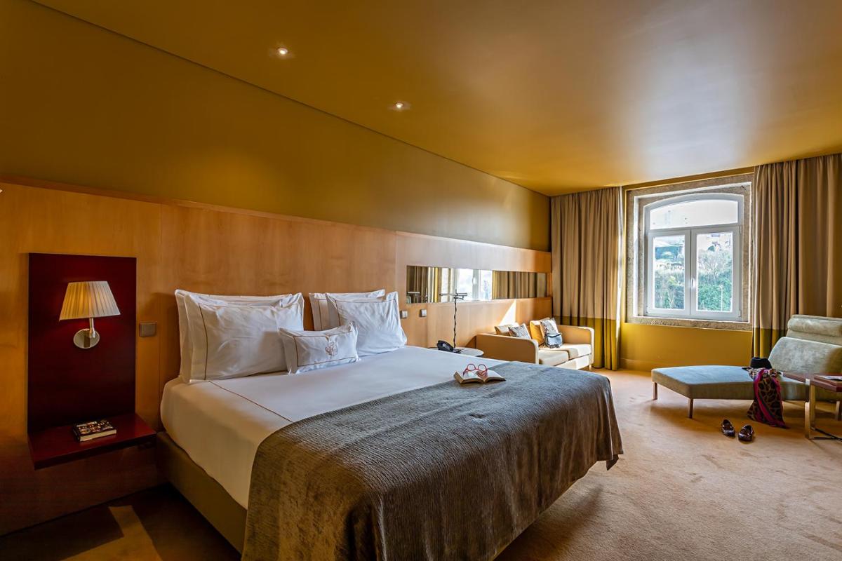 um quarto de hotel com uma cama grande e uma cadeira em Pestana Palacio do Freixo, Pousada & National Monument - The Leading Hotels of the World no Porto