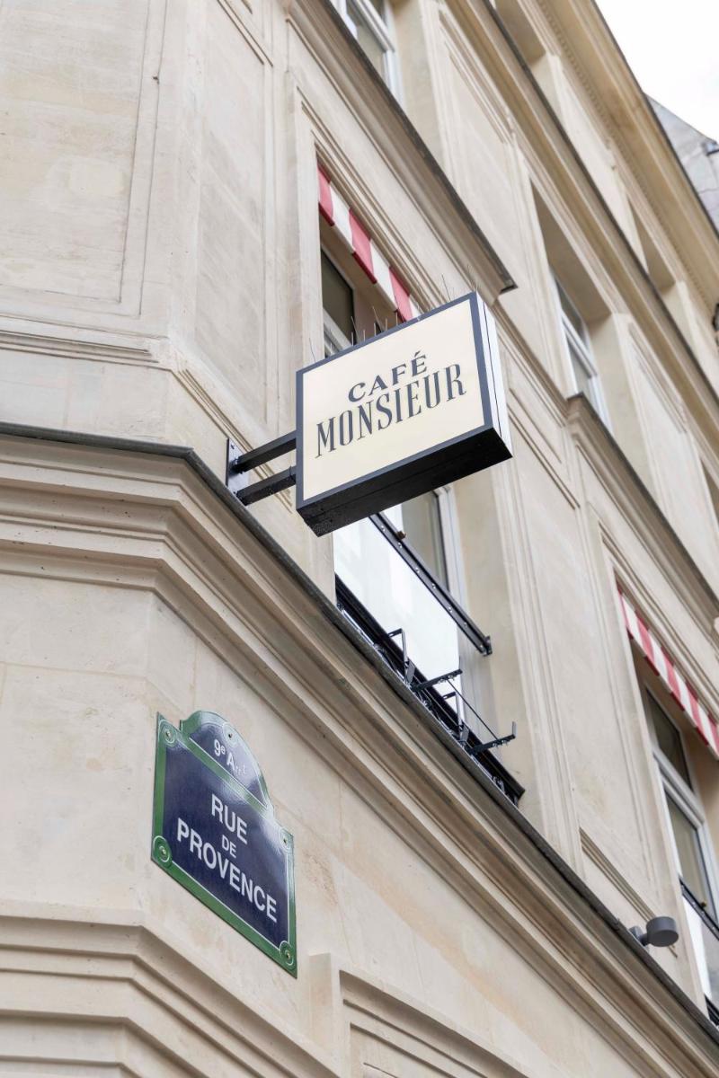un panneau sur le côté d'un bâtiment dans l'établissement Madame Drouot & Spa - Opera, à Paris