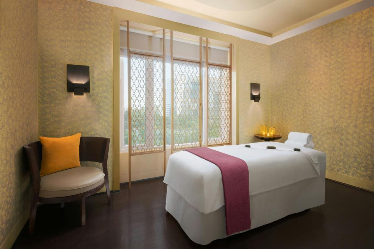 a bedroom with a large white bed and a window at Sheraton Hyderabad Hotel in Hyderabad