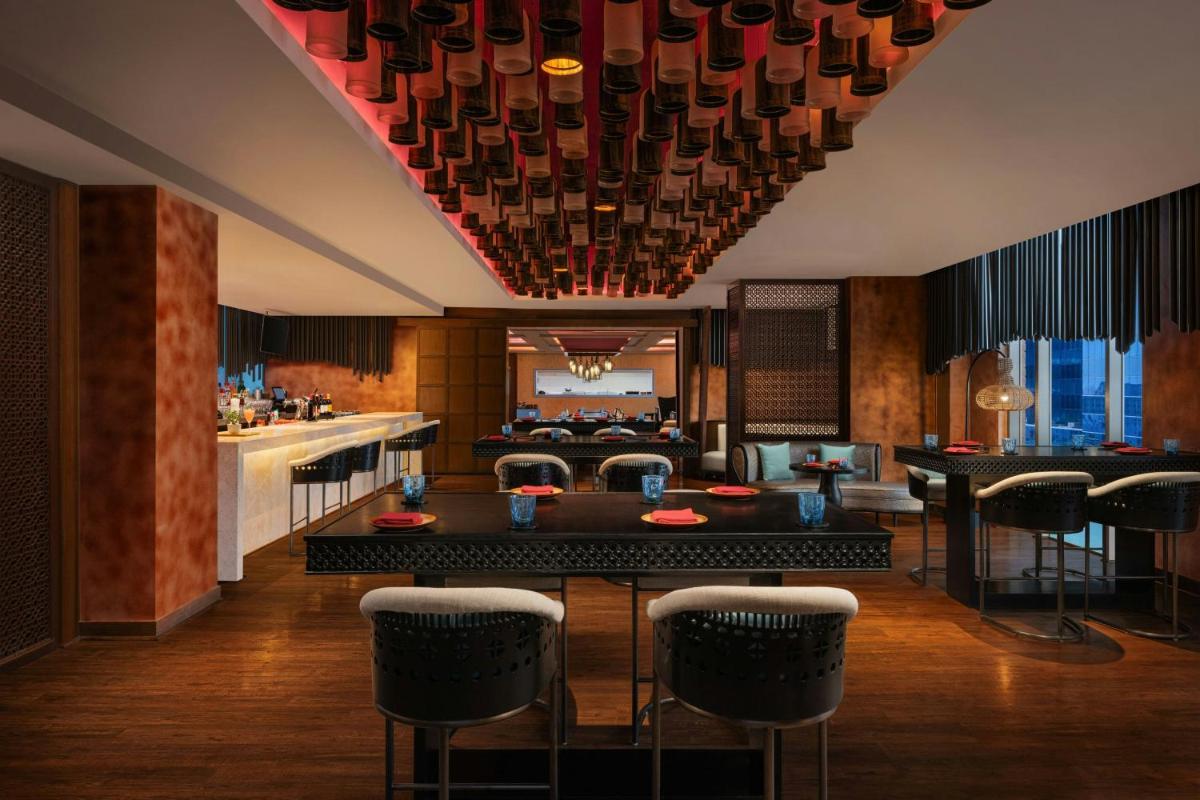 a dining room with a table and chairs at Sheraton Hyderabad Hotel in Hyderabad