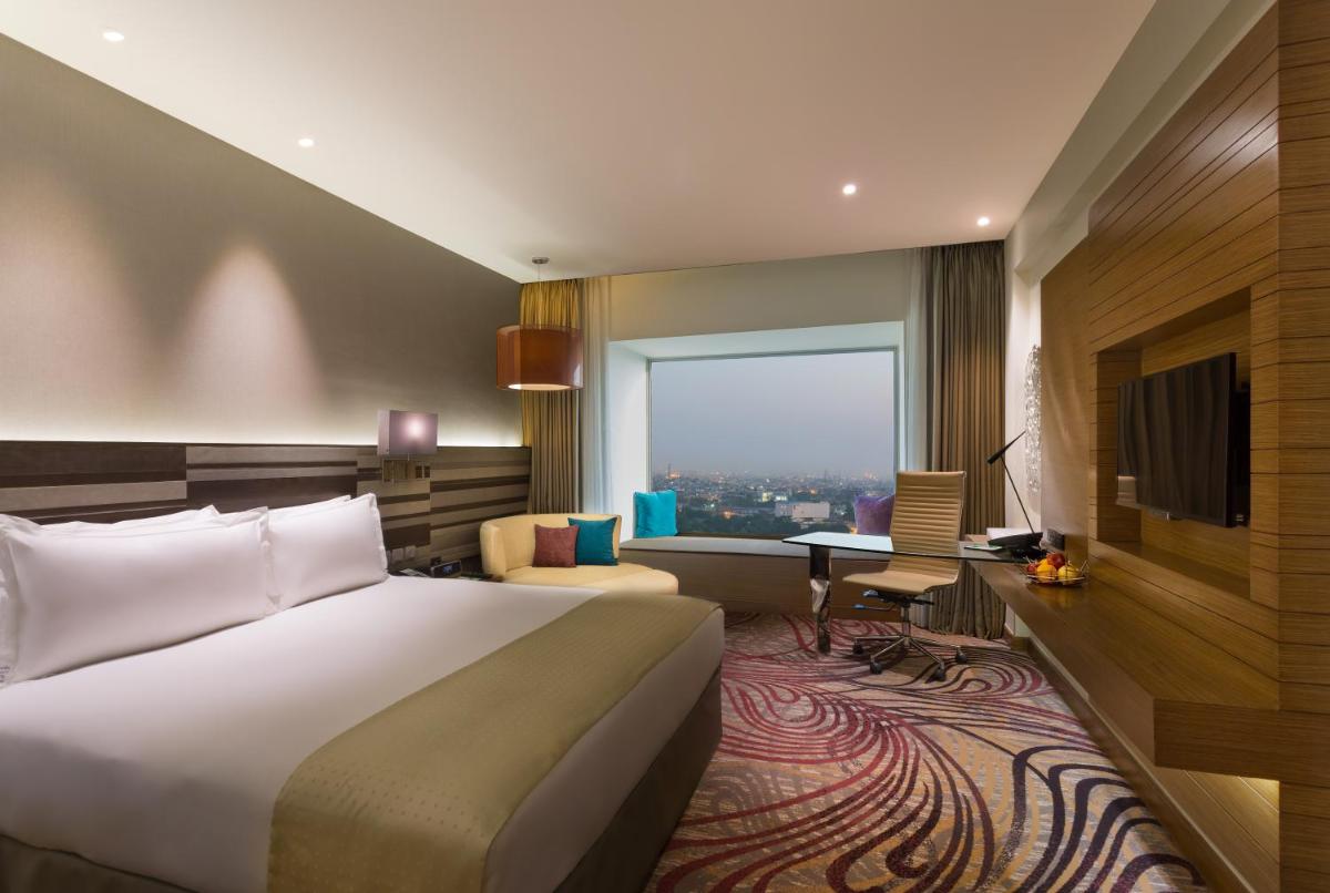 a hotel room with a bed and a desk at Holiday Inn Jaipur City Centre by IHG in Jaipur a hotel room with a bed and a desk at Holiday Inn Jaipur City Centre by IHG in Jaipur