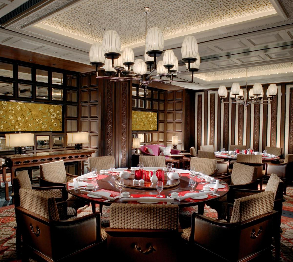a dining room with a large table and chairs at The Leela Palace Chennai in Chennai a dining room with a large table and chairs at The Leela Palace Chennai in Chennai