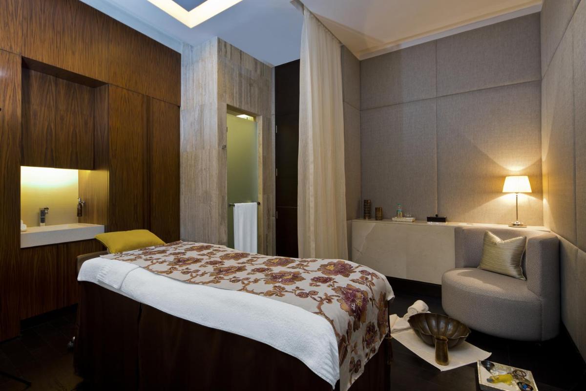 a hotel room with a bed and a bathroom at The Leela Palace Chennai in Chennai a hotel room with a bed and a bathroom at The Leela Palace Chennai in Chennai