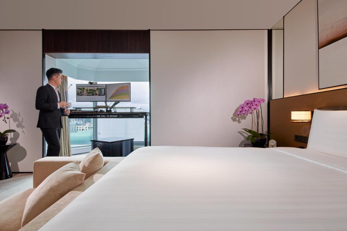 a man in a suit standing in a hotel room at Shangri-La Singapore in Singapore