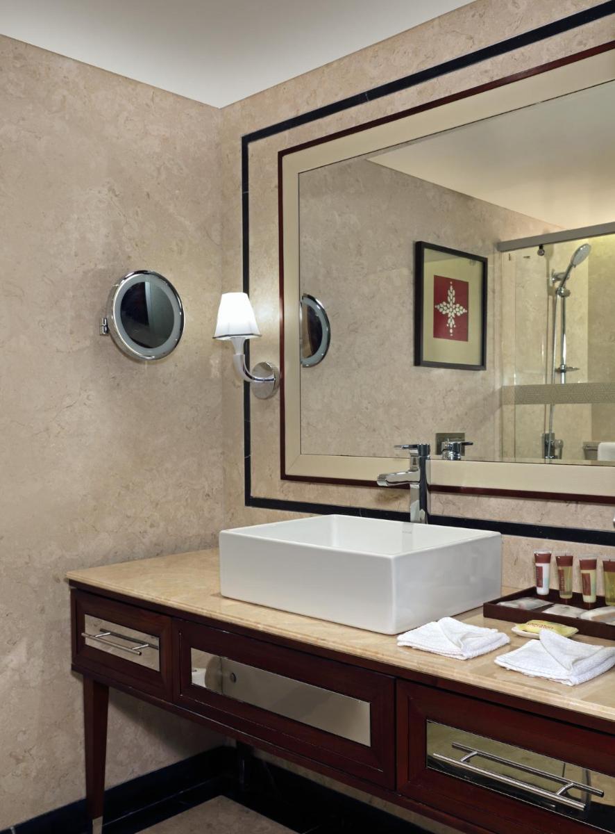 a bathroom with a sink and a large mirror at Sheraton Grand Pune Bund Garden Hotel in Pune