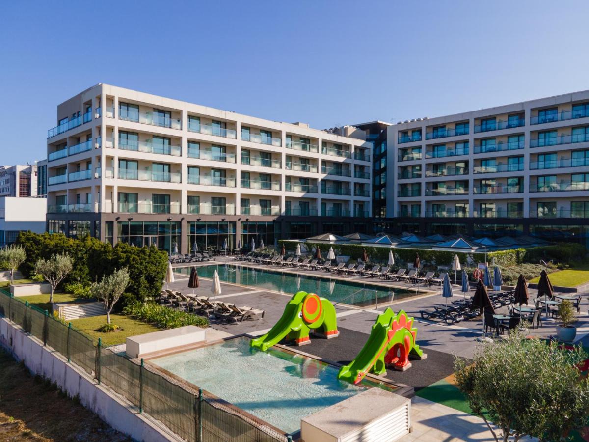 um hotel com piscina e um edifício em Vila Gale Coimbra em Coimbra
