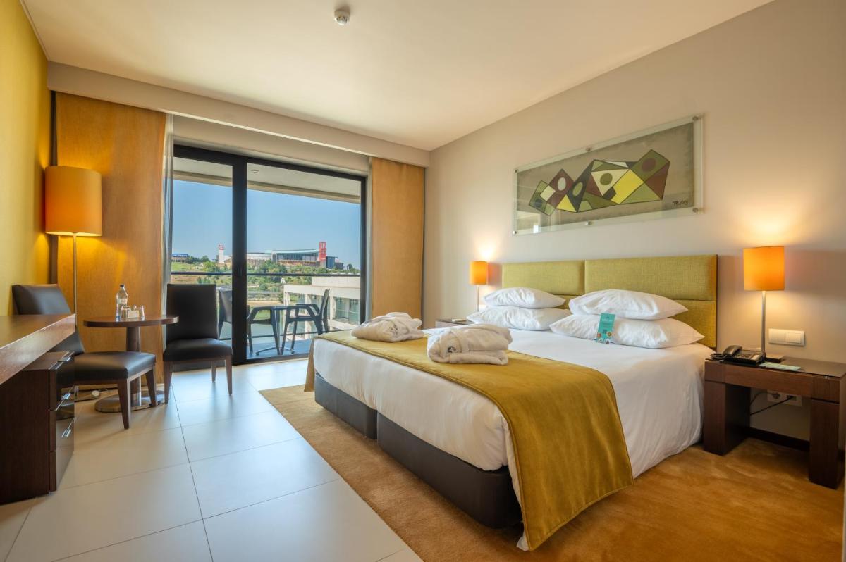 Uma cama ou camas num quarto em Vila Gale Coimbra