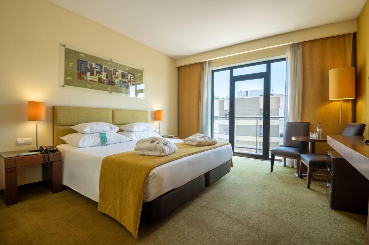 Uma cama ou camas num quarto em Vila Gale Coimbra