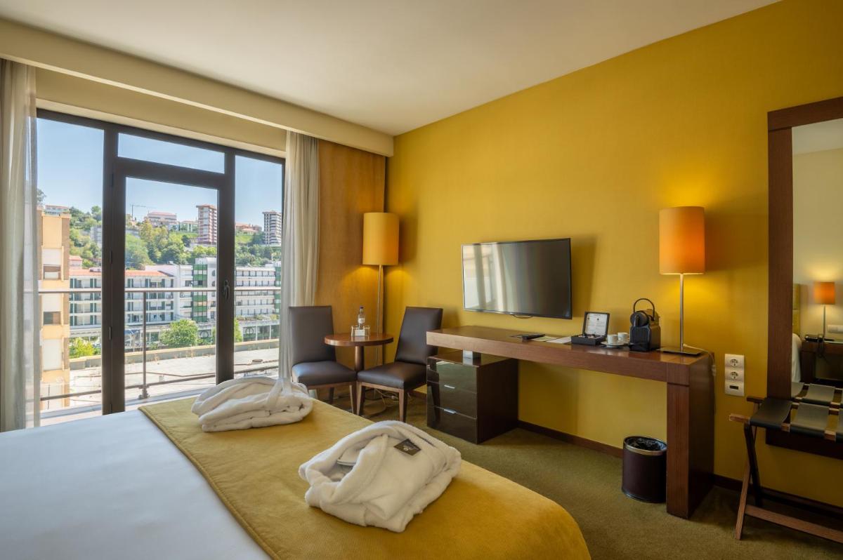 Uma cama ou camas num quarto em Vila Gale Coimbra