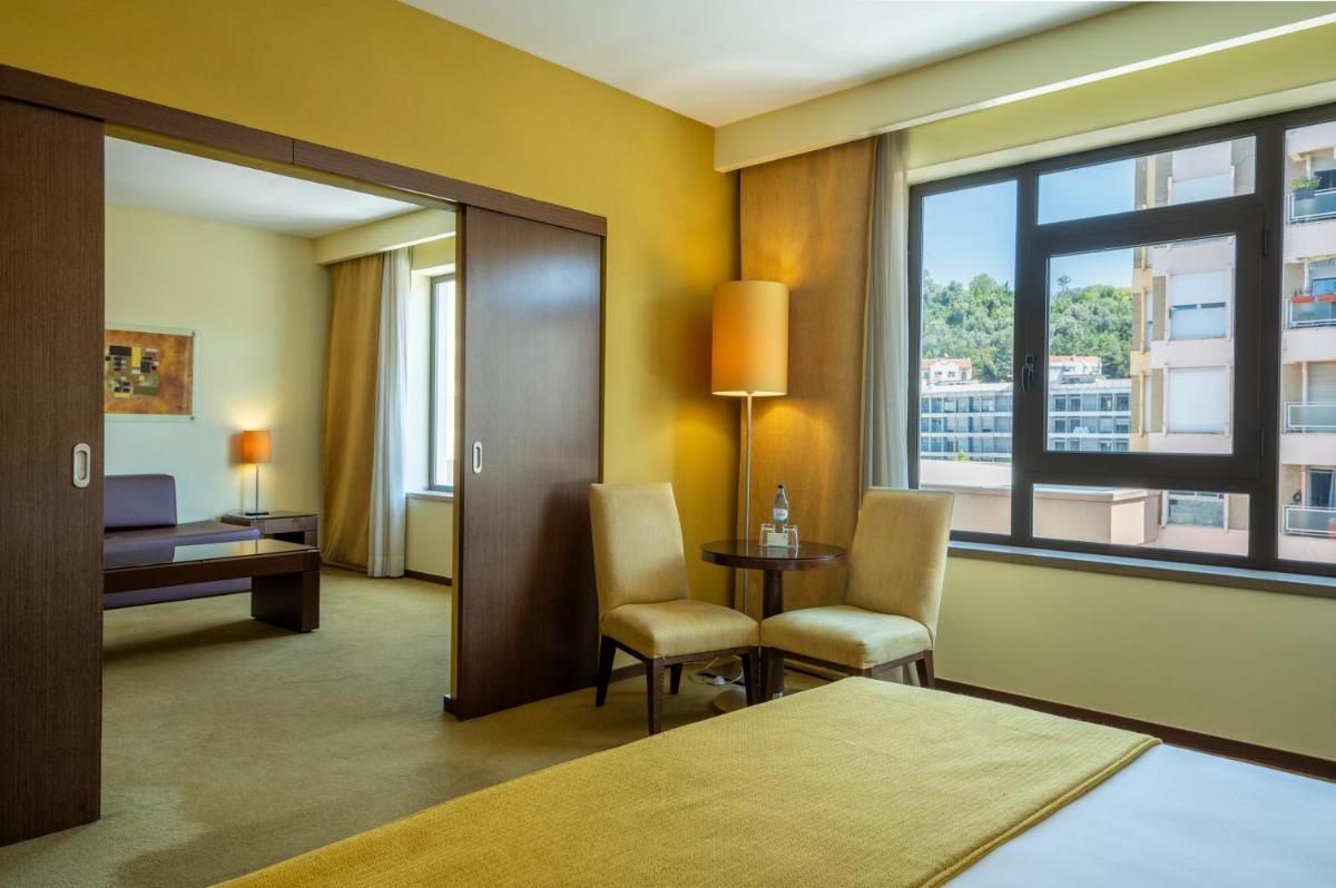 Uma cama ou camas num quarto em Vila Gale Coimbra