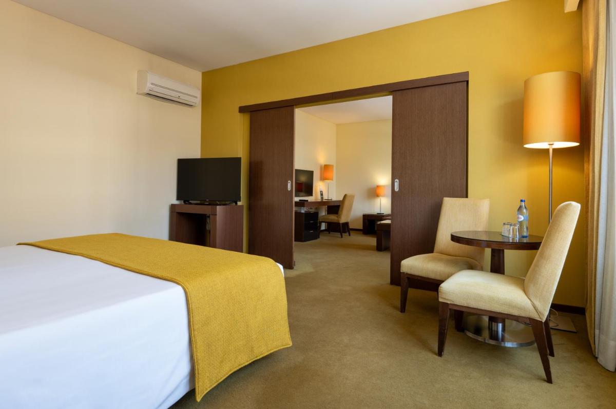 Uma cama ou camas num quarto em Vila Gale Coimbra