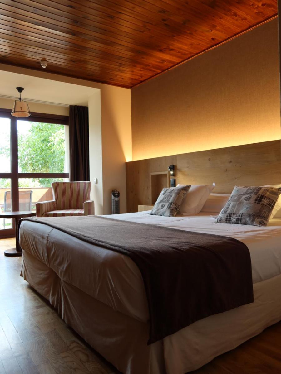 Un dormitorio con una cama grande y una mesa. en Hotel La Morera, en Valencia de Aneu 28 fotos más