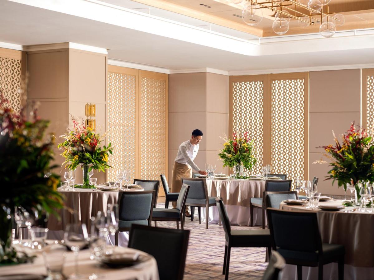 a man standing in the middle of a banquet hall with tables at Pullman Chennai Anna Salai - Premium Brand By Accor in Chennai