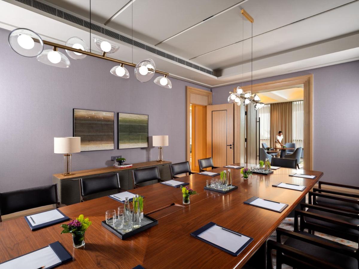 a conference room with a large wooden table and chairs at Pullman Chennai Anna Salai - Premium Brand By Accor in Chennai