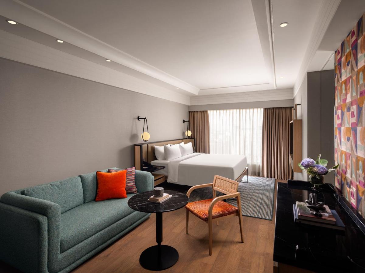 a living room with a couch and a bed at Pullman Chennai Anna Salai - Premium Brand By Accor in Chennai
