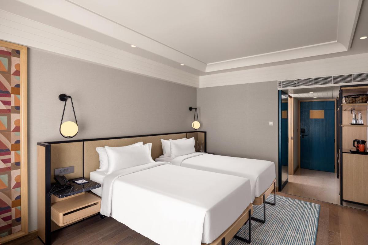 a bedroom with two white beds in a room at Pullman Chennai Anna Salai - Premium Brand By Accor in Chennai