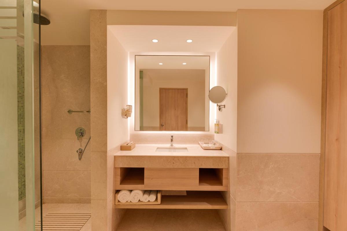 a bathroom with a sink and a mirror at Lemon Tree Premier Hitec City Hyderabad in Hyderabad