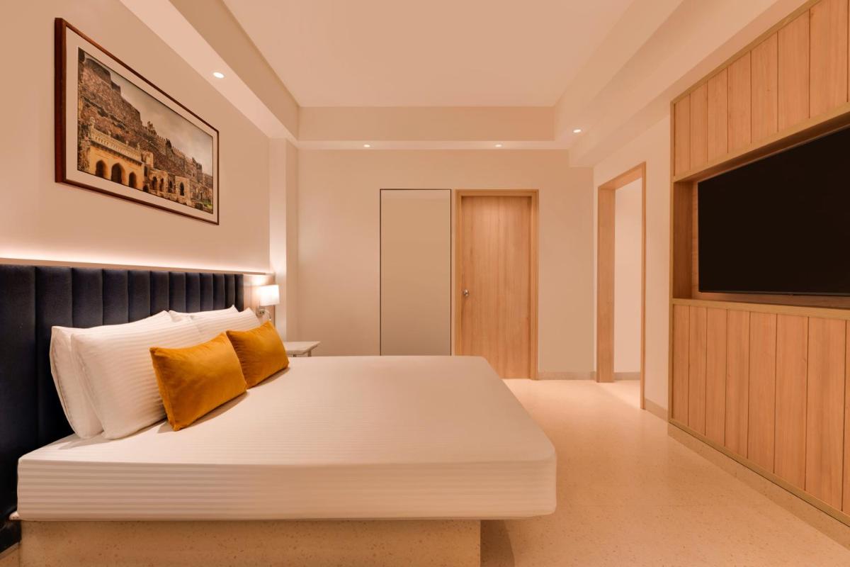 a bedroom with a bed and a flat screen tv at Lemon Tree Premier Hitec City Hyderabad in Hyderabad
