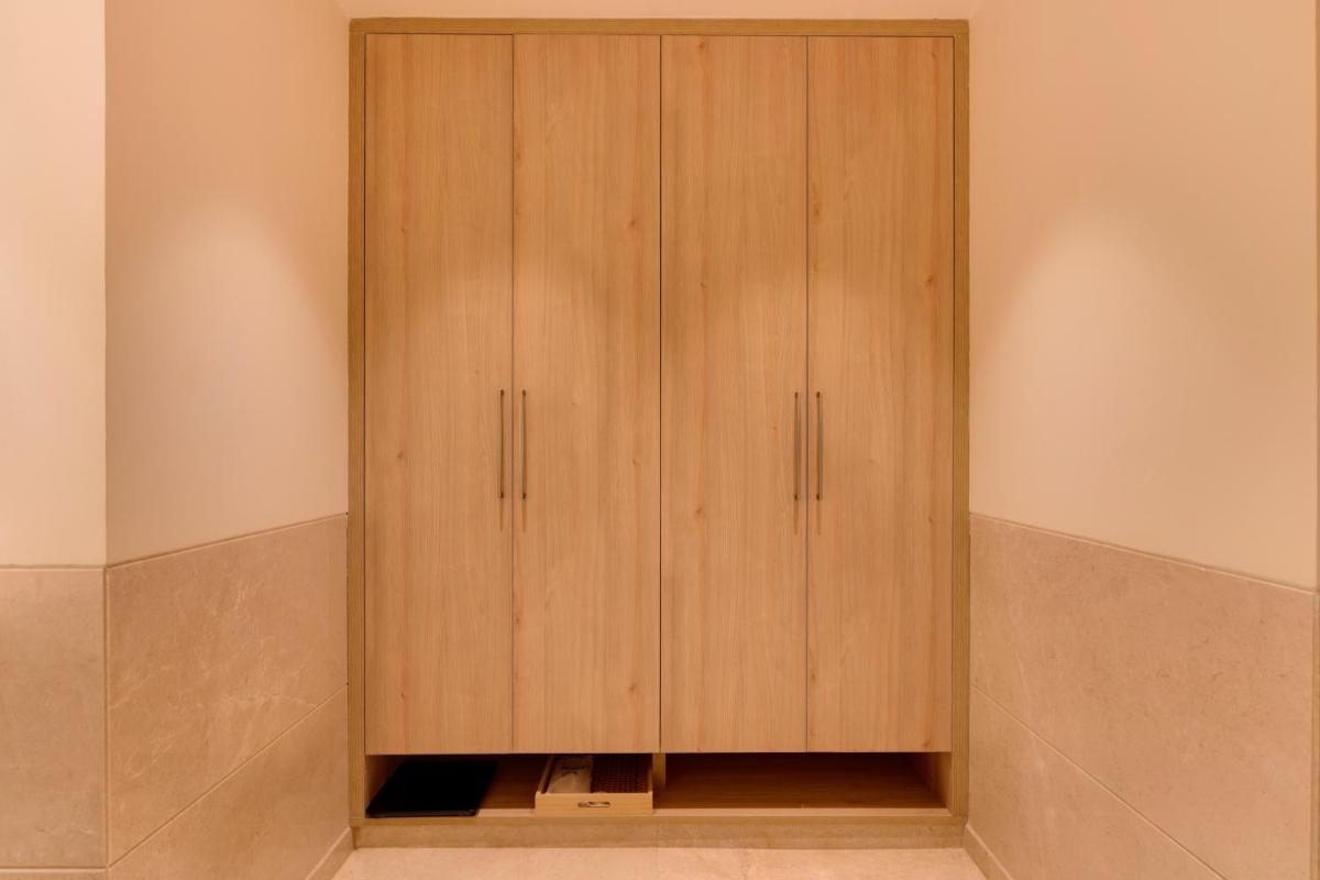 a closet with wooden cabinets in a room at Lemon Tree Premier Hitec City Hyderabad in Hyderabad