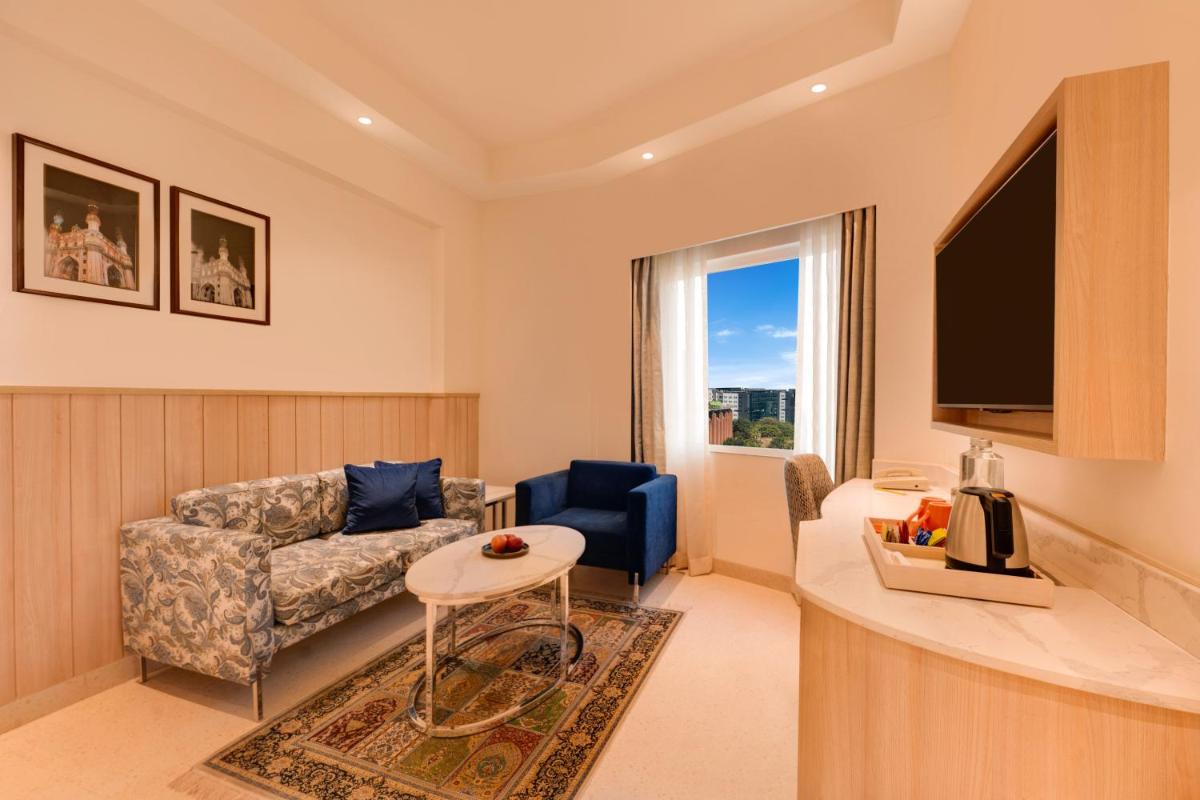 a living room with a couch and a tv at Lemon Tree Premier Hitec City Hyderabad in Hyderabad