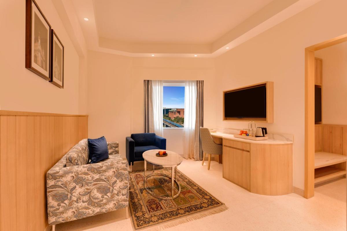 a living room with a couch and a table at Lemon Tree Premier Hitec City Hyderabad in Hyderabad