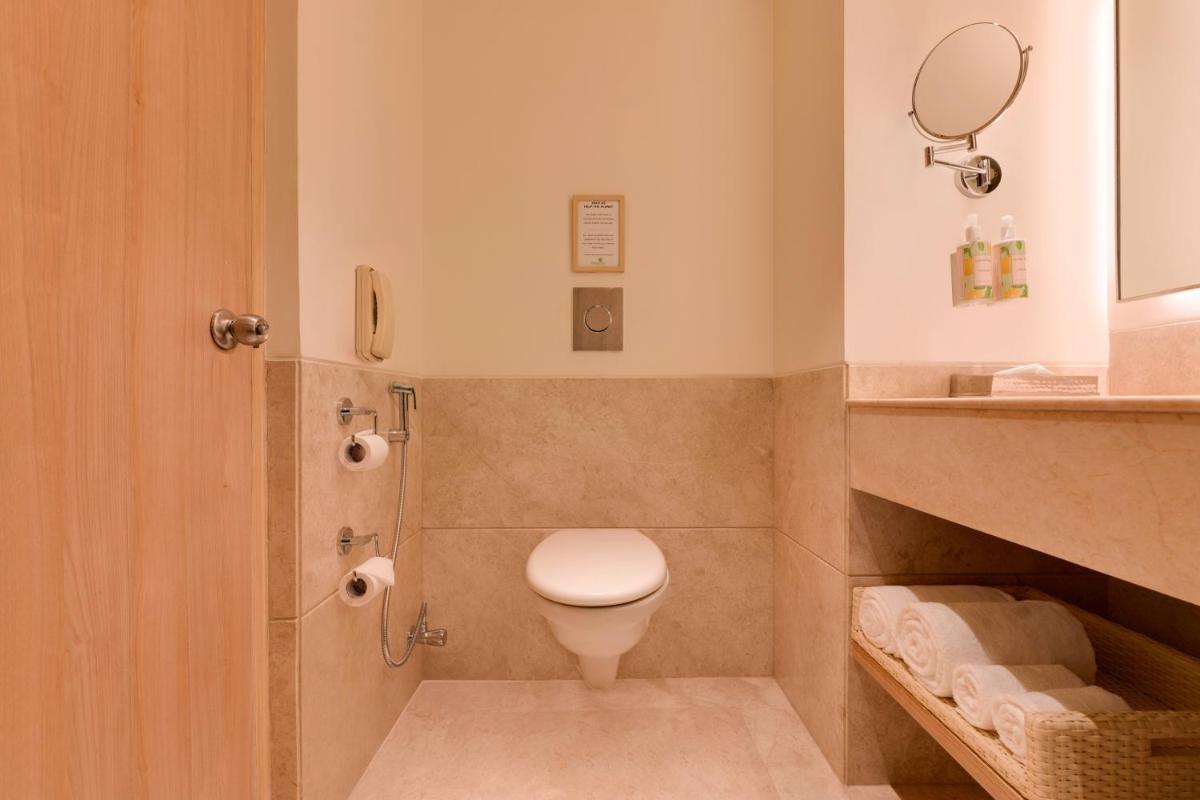 a bathroom with a toilet and a sink at Lemon Tree Premier Hitec City Hyderabad in Hyderabad